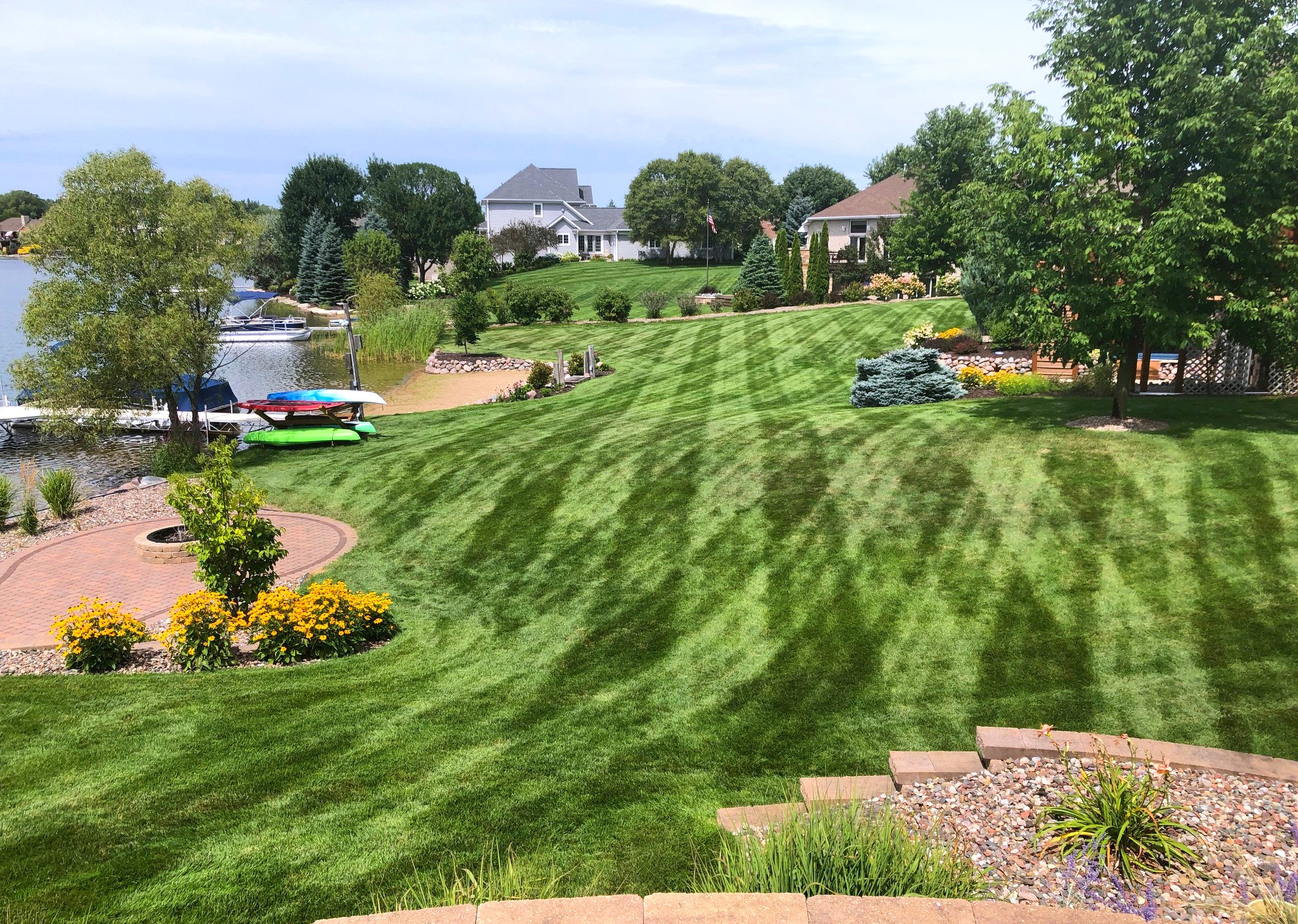 Cut grass near a lake with houses